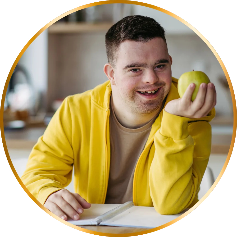 Disabled man sitting at table holding apple